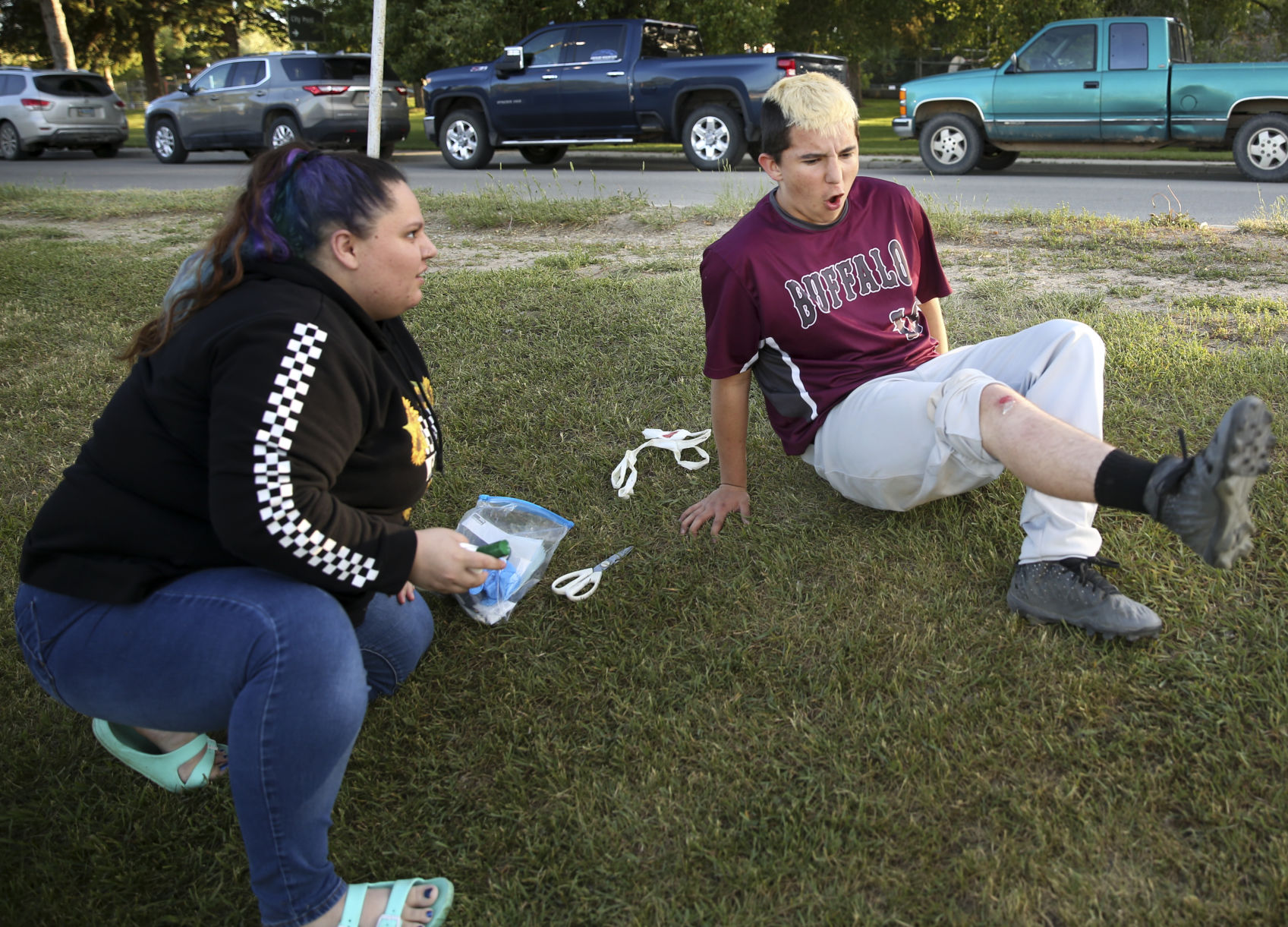 Terrance Neill pulls his newly scraped knee away from his sister Shaye after she added disinfectant